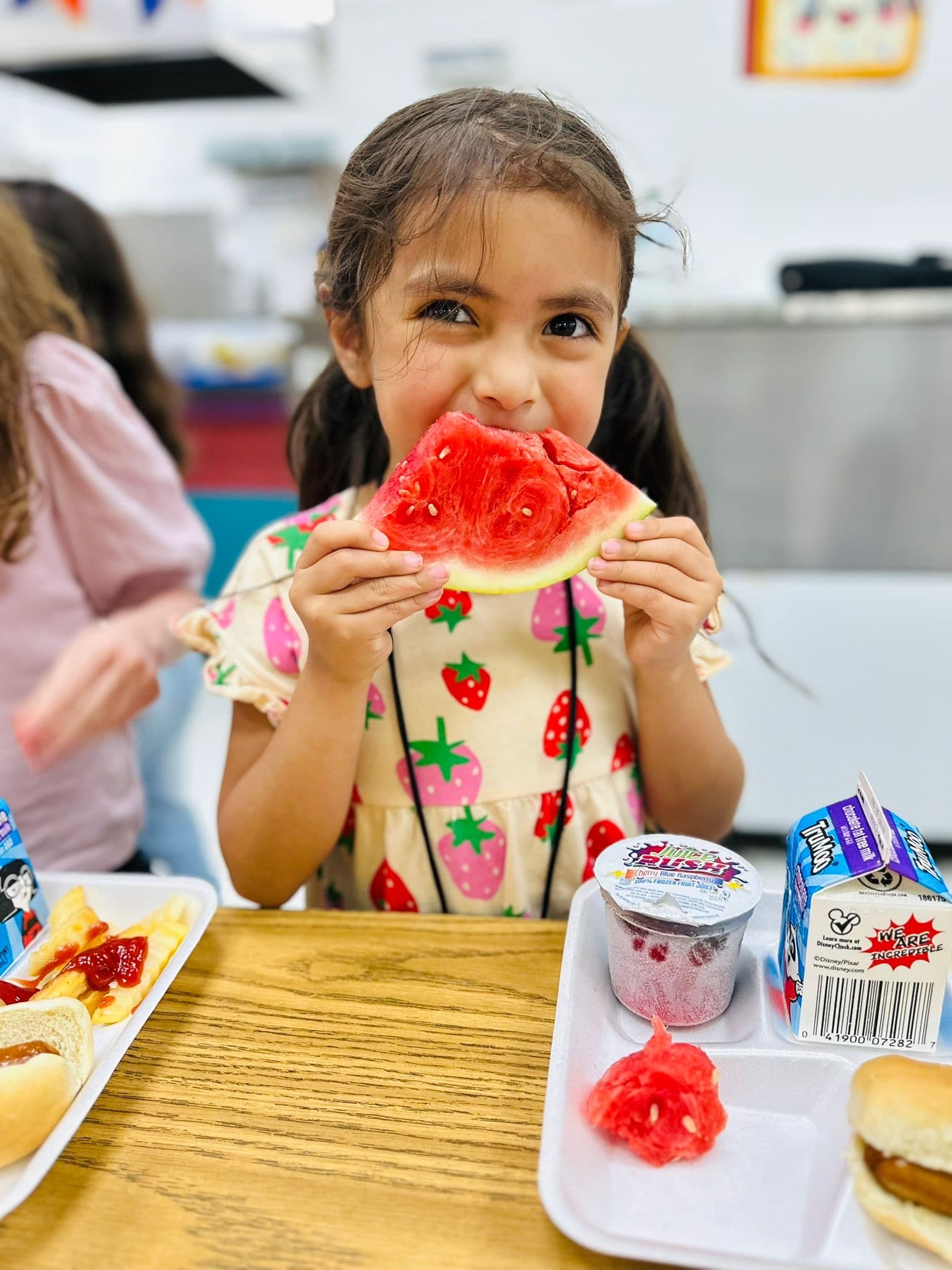 A young Club member enjoying a slice of watermelon at snack time