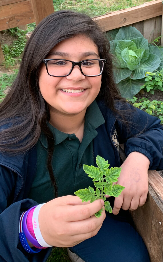 girl showing off an herb she grew
